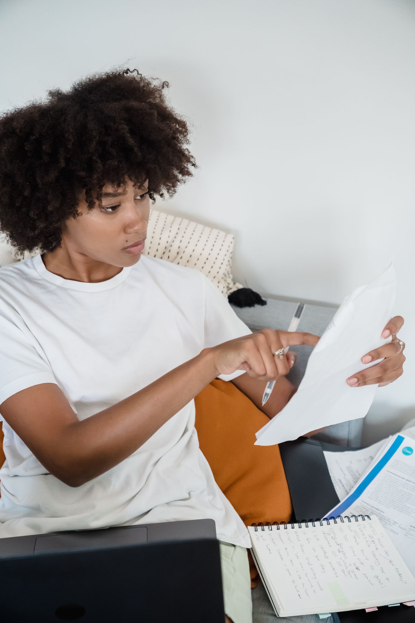 Applicant reviewing documents beside a laptop at home